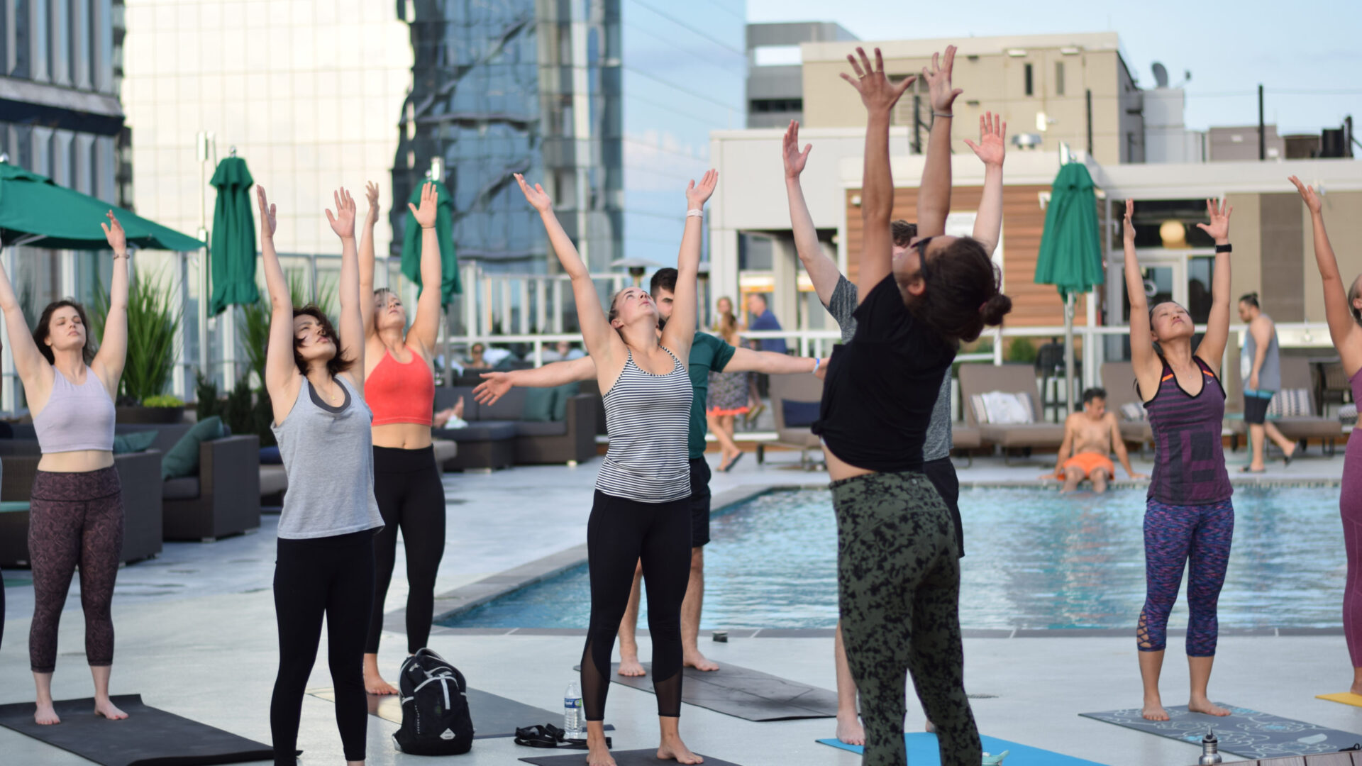 City Fitness members in a rooftop poolside yoga in Philadelphia